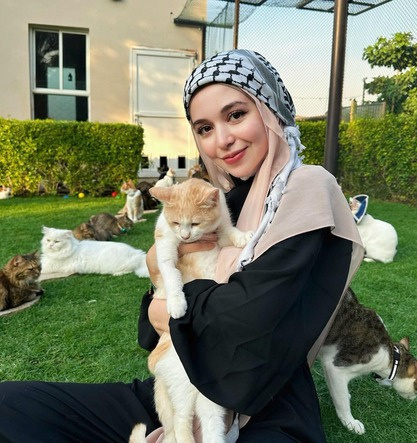Community caregiver with cats in a landscaped UAE residential community